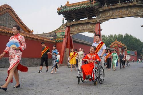 图为志愿者协助身着旗袍的残障女性体验盛京古韵文化