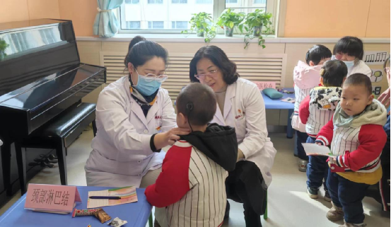图为康复中心党总支党员为在训听障儿童进行公益健康体检